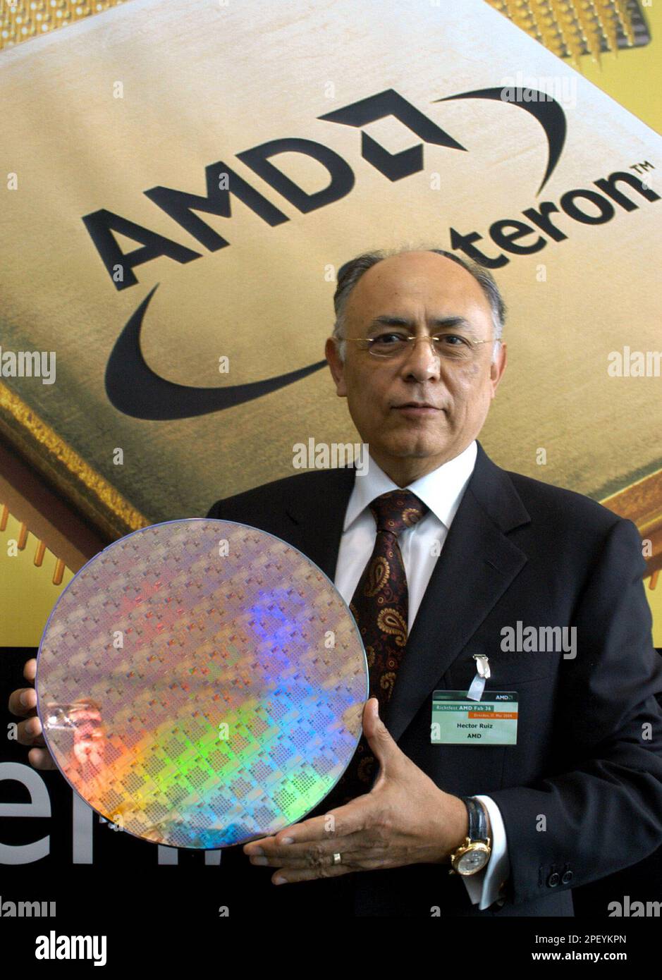 Hector Ruiz, Chairman of the Board and CEO of AMD, Advanced Micro Devices, poses with a 300 Millimeter wafer prior to the beginning of the topping-off ceremony for AMD`s extension wing Fab 36, in Dresden, Germany, Monday, May 17, 2004. AMD, a global semiconductor company, based in Sunnyvale, Calif., opened its biggest wafer production line, the Fab 30, outside the U.S. in Dresden in 1999 and is celebrating the topping-off of the new Fab 36 hall on Monday. (AP photo/Matthias Rietschel) Stock Photo
